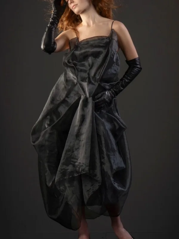 Model wearing a sculptural black organza dress with a gathered, billowing skirt and gloves