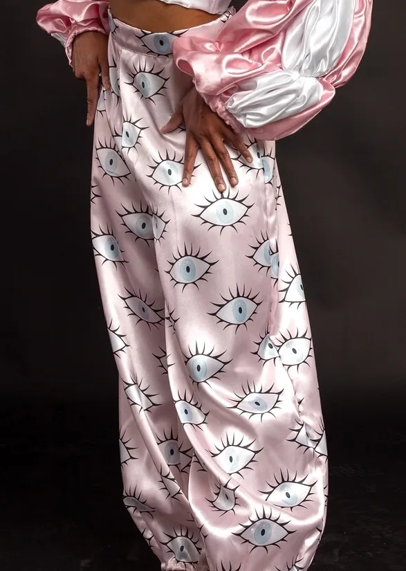 The eye-print fabric realized as pink satin pants, worn with puffed satin sleeves