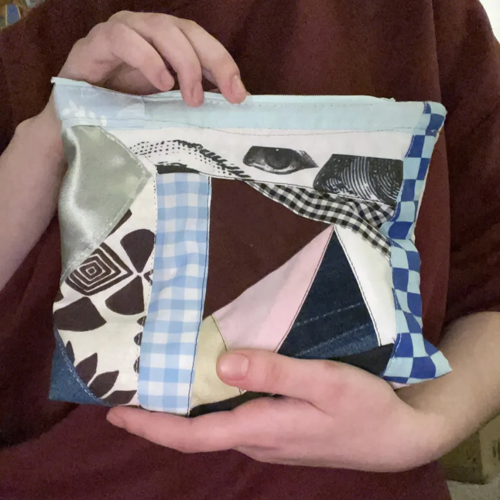 Patchwork zip pouch made from upcycled fabric scraps — gingham, denim, checkerboard and printed cotton